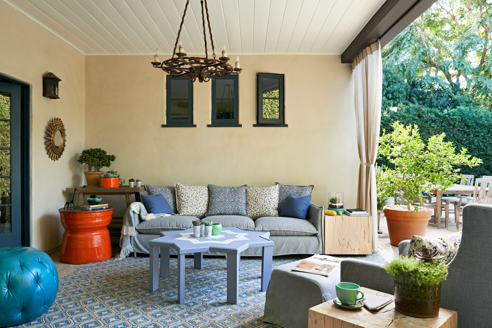 The outdoor sofa is soft and inviting. A mix of textures and patterns in the monochromatic blues adds visual interest, while a bright orange side table adds a fun burst of color. The Moroccan table in the center of the room was custom built for this space.